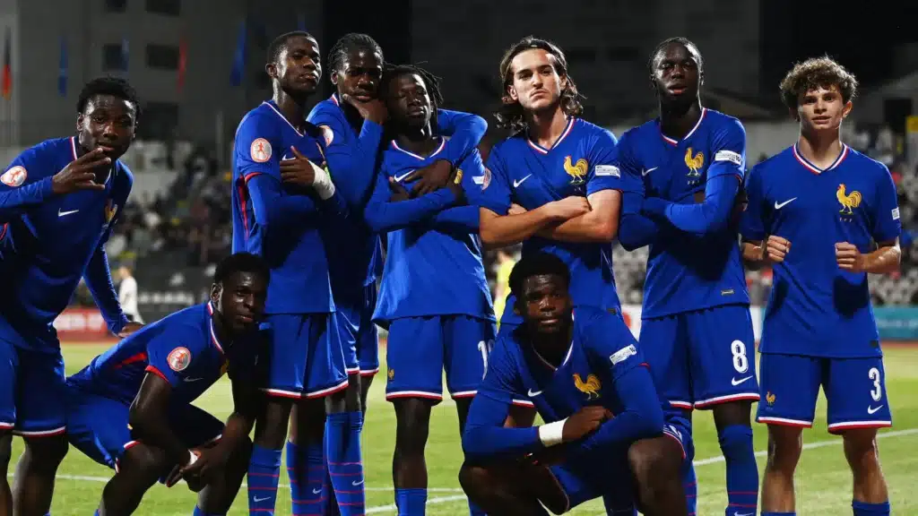 France national football team players in blue uniforms posing together on a soccer field after a match.